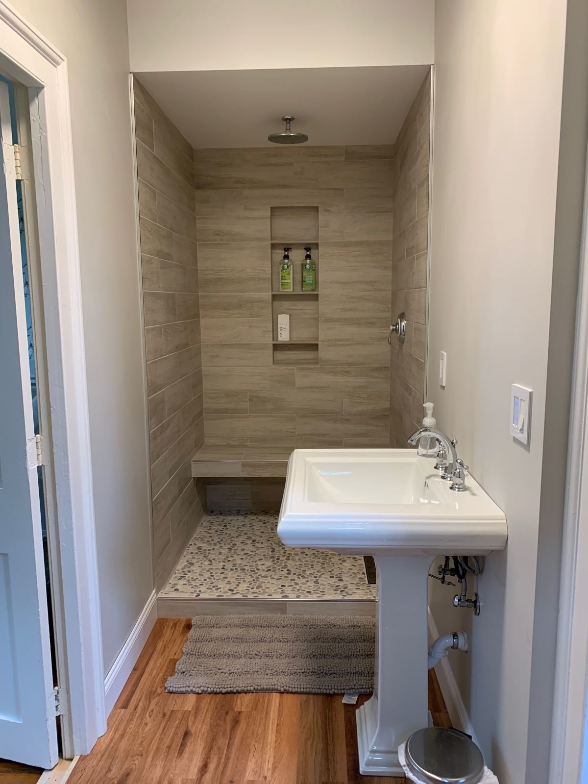 A bathroom with a sink and a walk in shower.