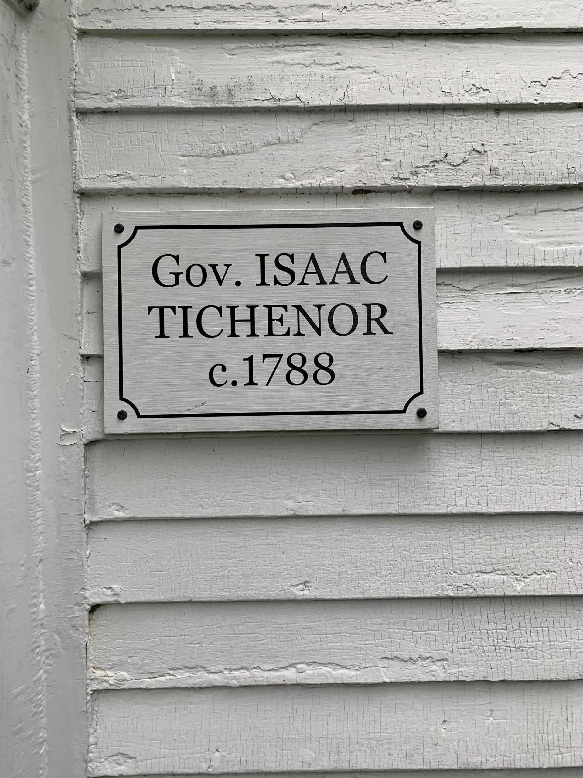 A black and white photo of a sign on the side of a building.