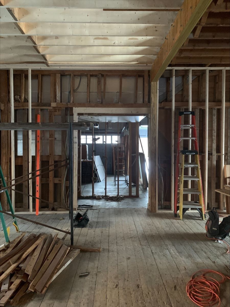 A room under construction with a ladder and a bunch of wood