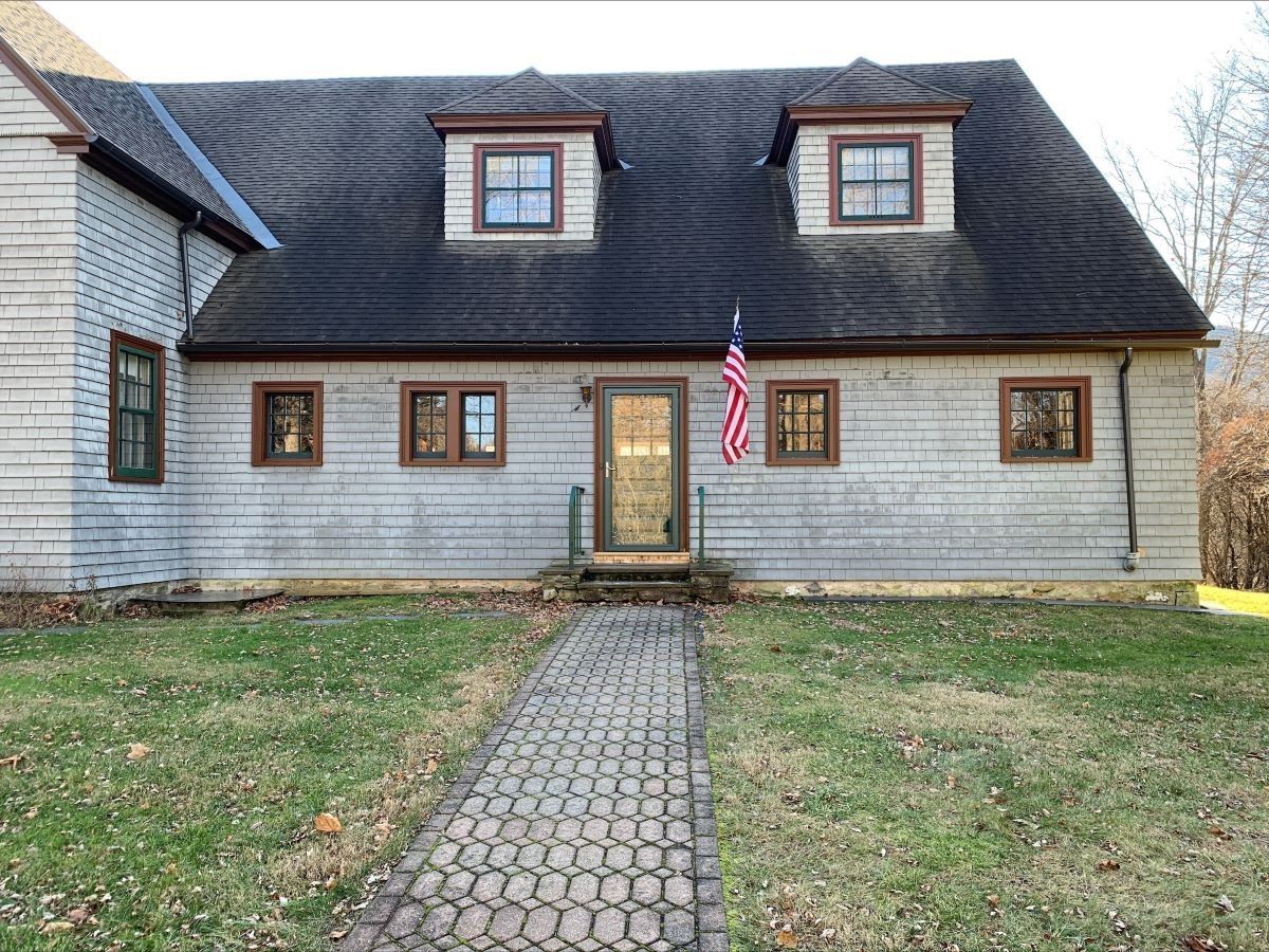 A house with a flag on the front of it and a walkway leading to it.