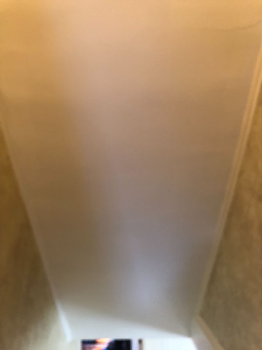 A person is standing in a room with a white ceiling.