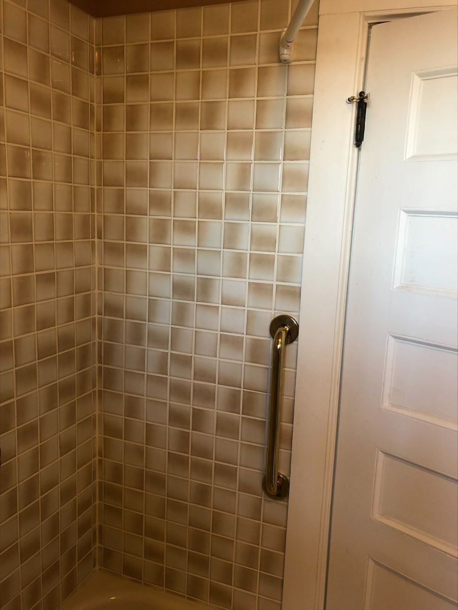 A bathroom with a walk in shower and a door.