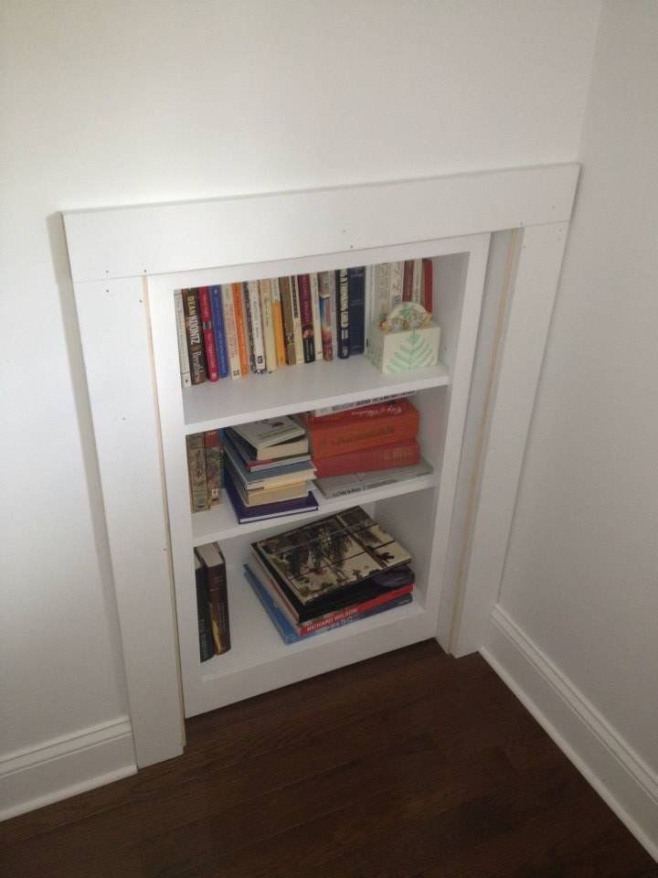 A bookshelf filled with books in a corner of a room