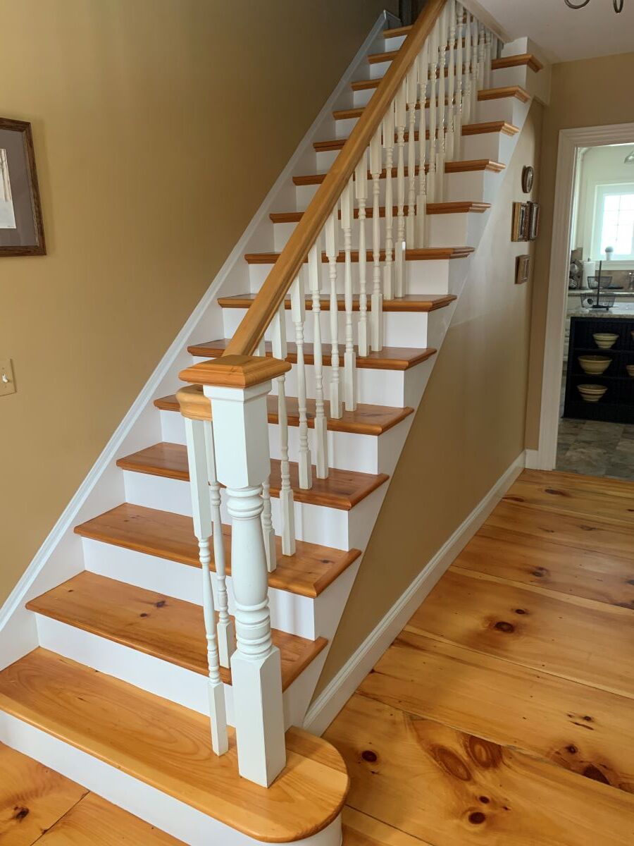 A staircase with wooden steps and a white railing