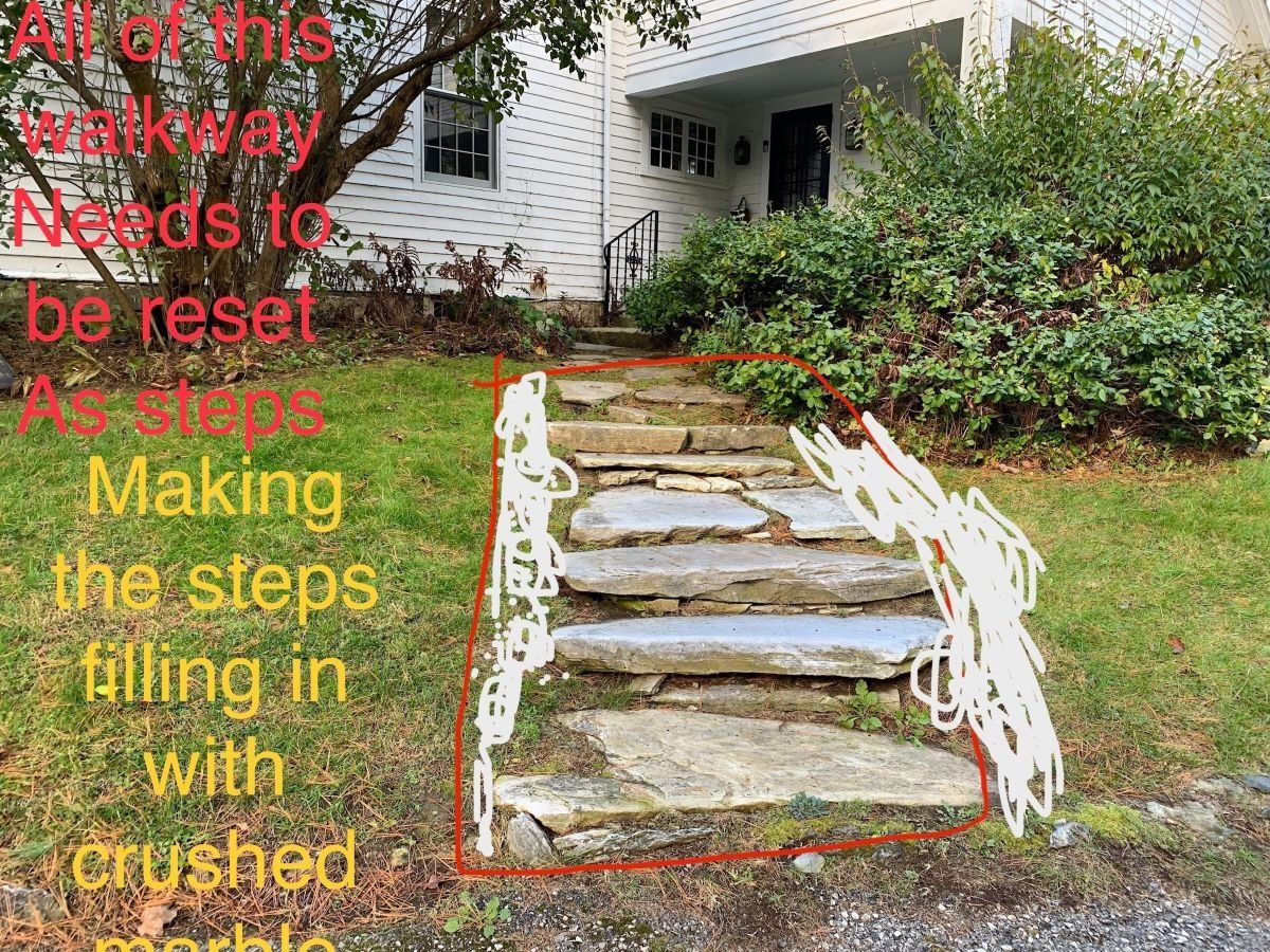A picture of a stone walkway in front of a house.