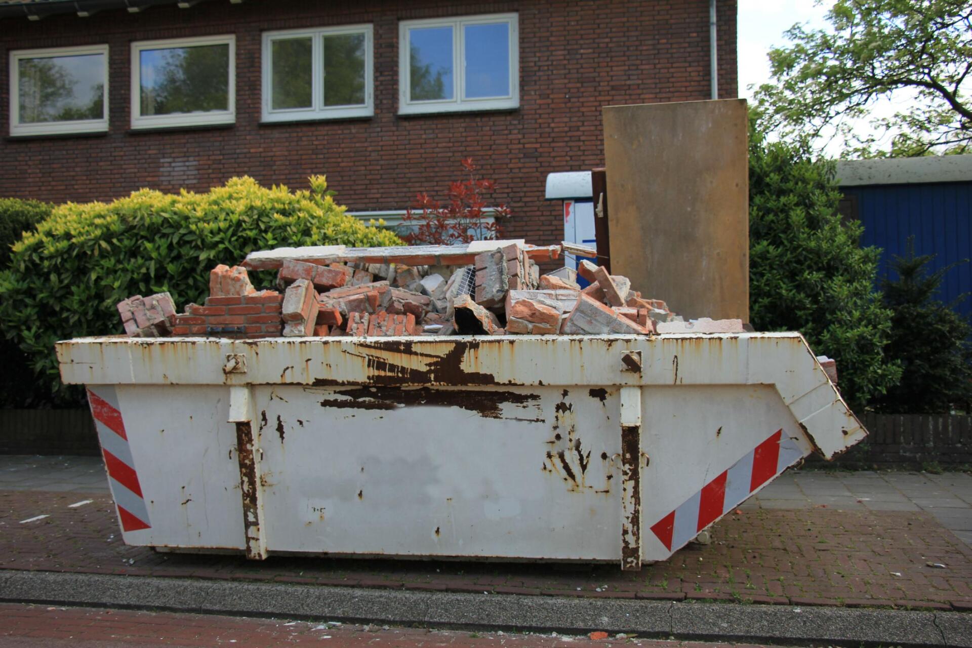 white old dumpster with wall bricks