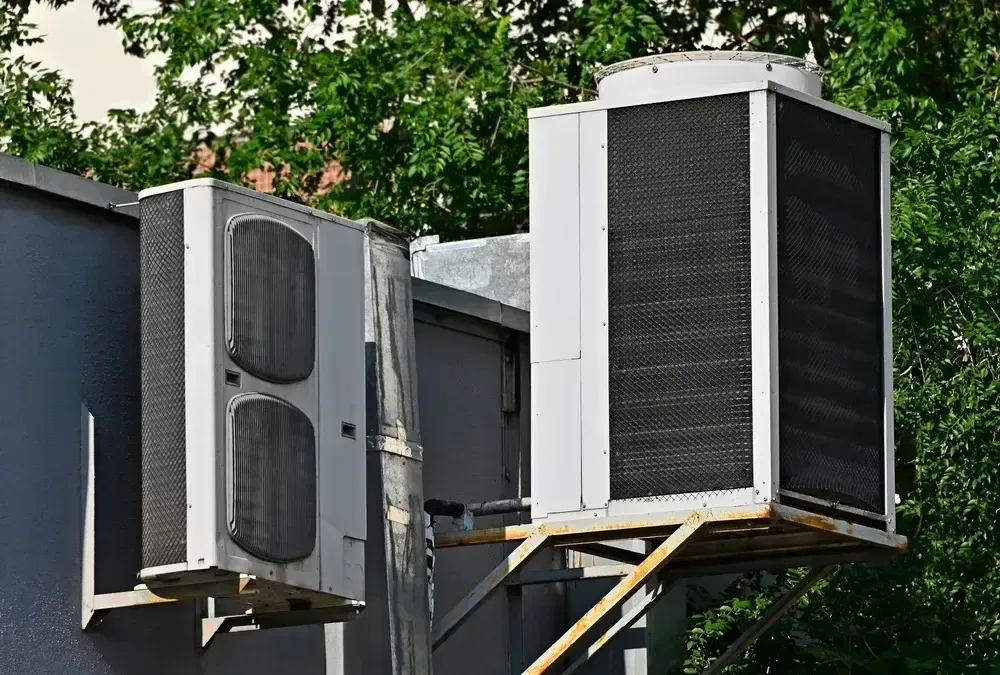 Exterior view of a sleek modern house with air source heat pumps neatly installed on the outside.