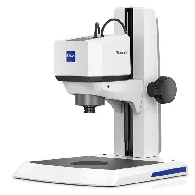 A white zeiss microscope is sitting on a white surface.