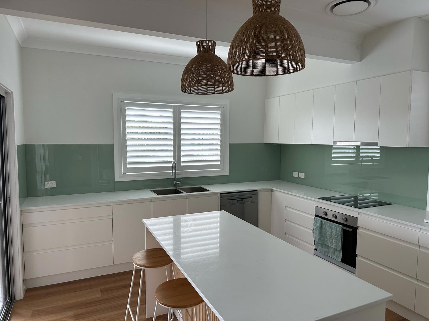 A Kitchen with White Cabinets, a Large Island, a Stove and A Sink—Colour Splash in Nelson Bay, NSW
