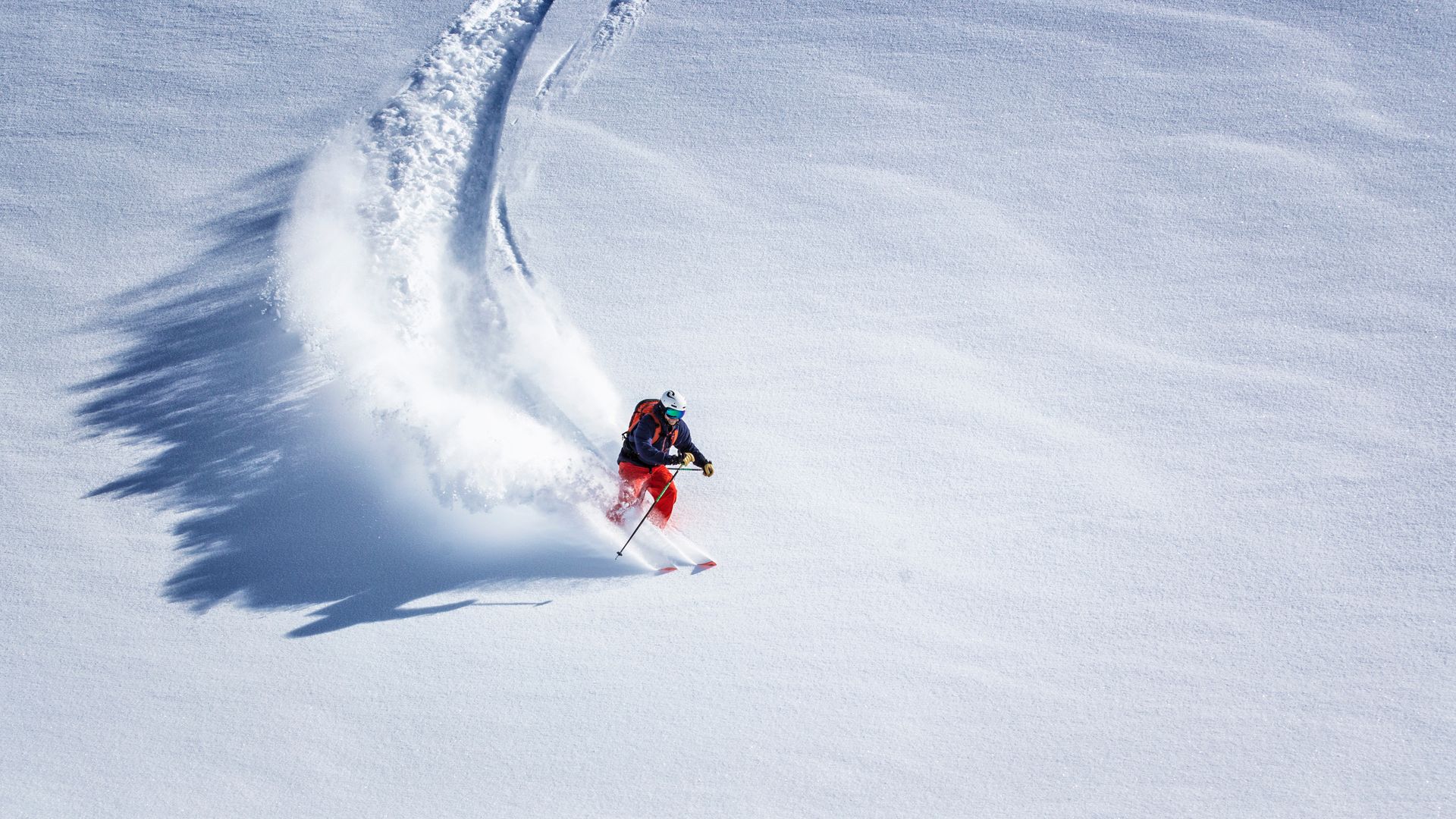 A person is skiing down a snow covered slope.