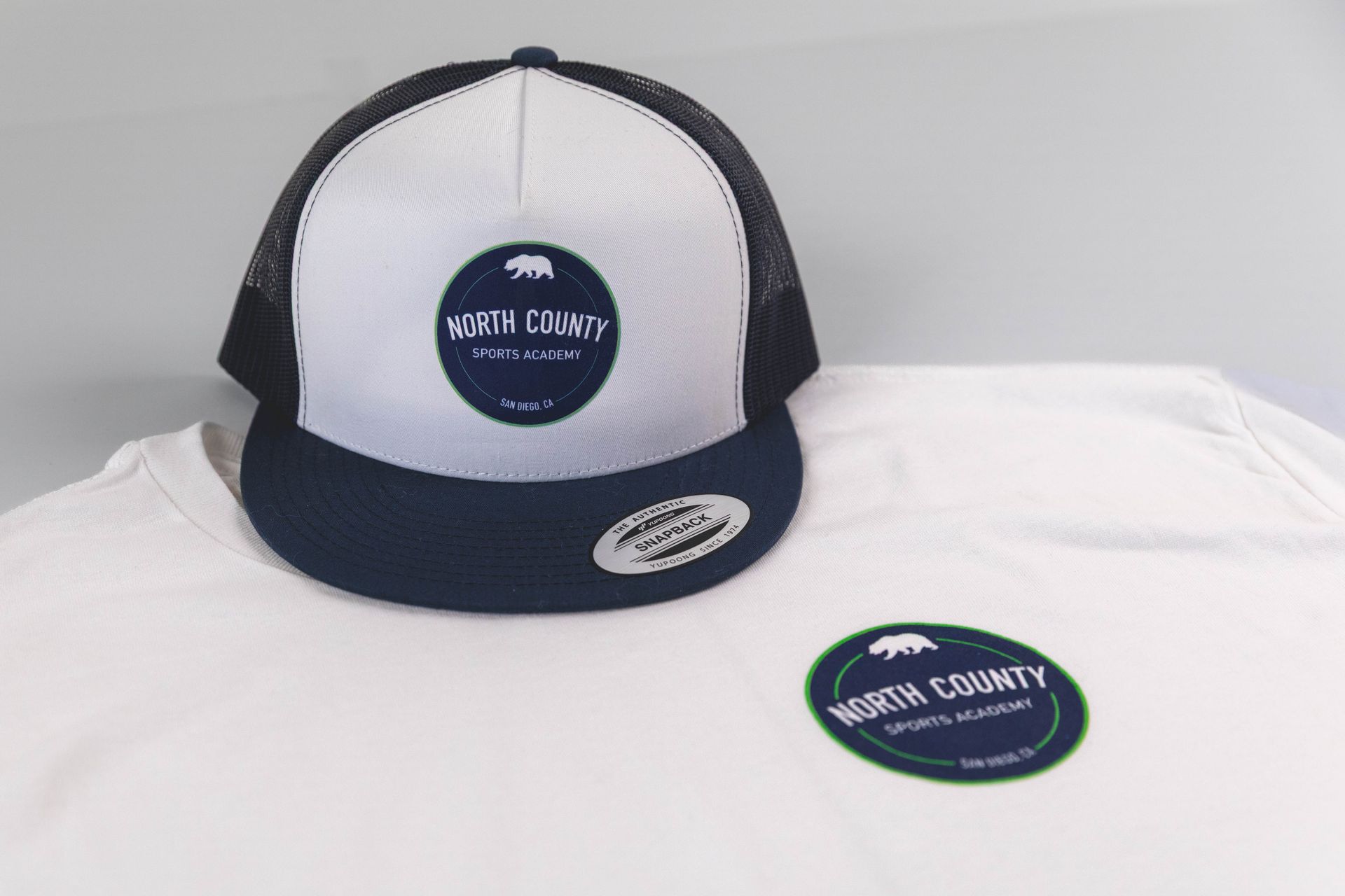 White and navy trucker cap with circular logo on a white background