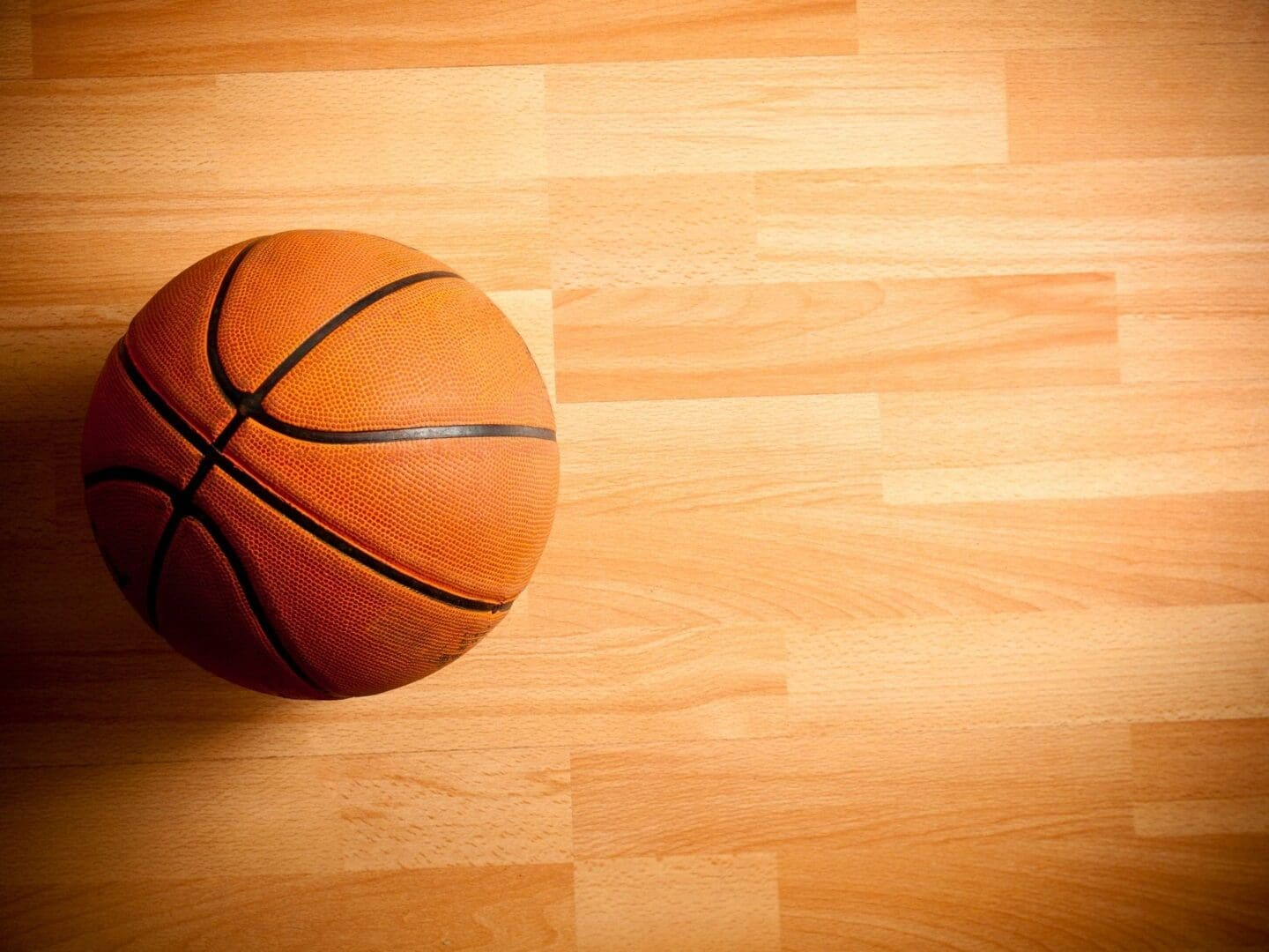 Orange basketball on a light wooden floor