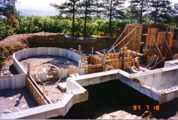 Construction site showing concrete foundation forms for a house with a circular room, dated July 18, 1997.