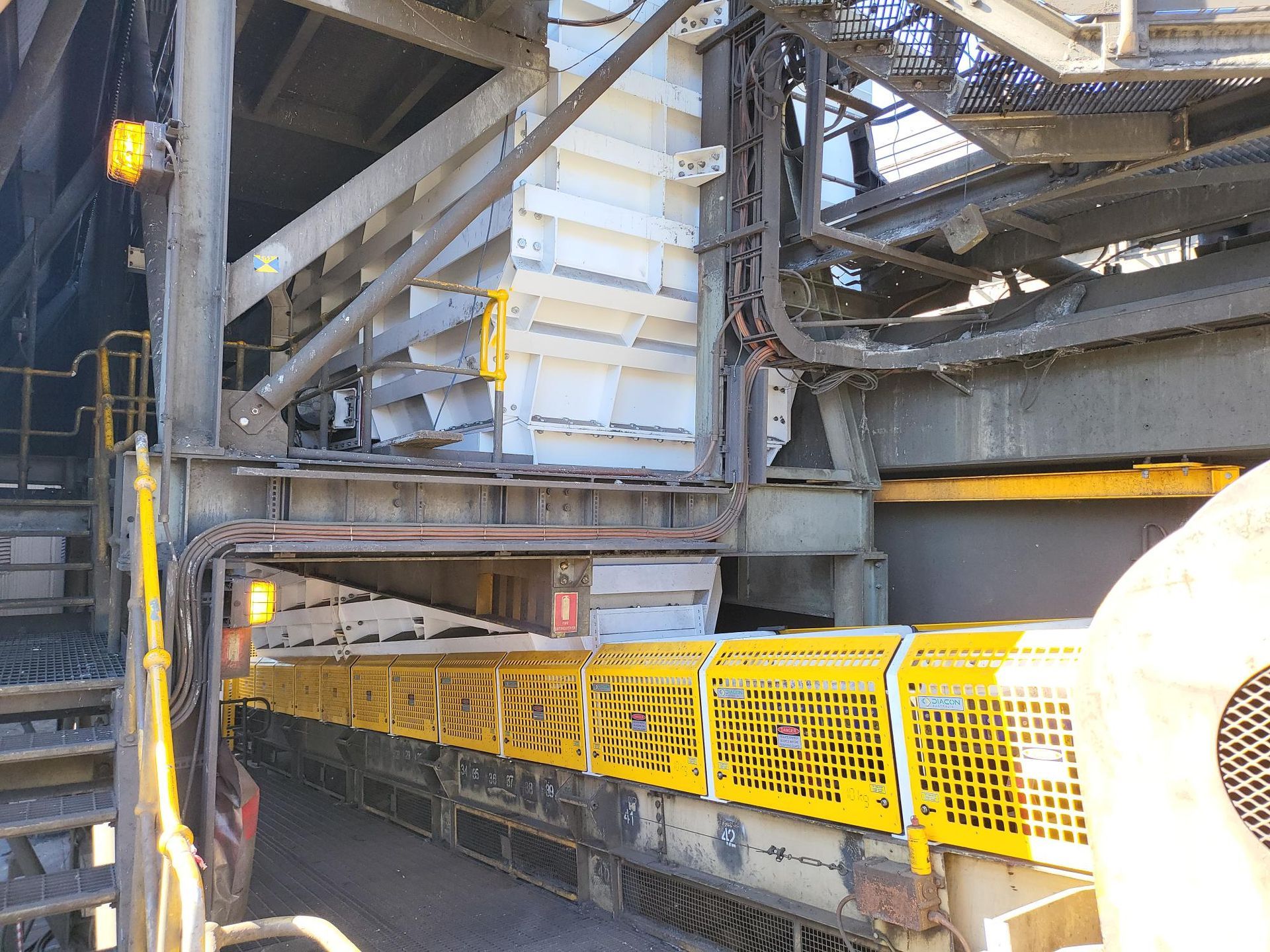 A Yellow Fence Is Surrounding A Train Car In A Factory — Custom Steel Fab in Garbutt, QLD