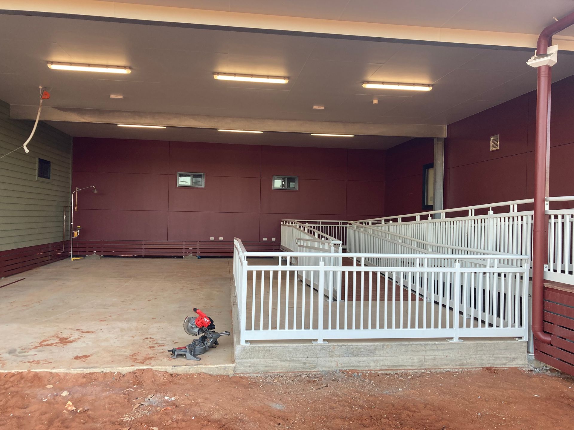 An Empty Room With A White Railing And A Red Wall — Custom Steel Fab in Garbutt, QLD