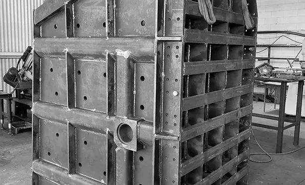 A Black and White Photo of A Large Metal Structure in A Factory — Custom Steel Fab in Garbutt, QLD