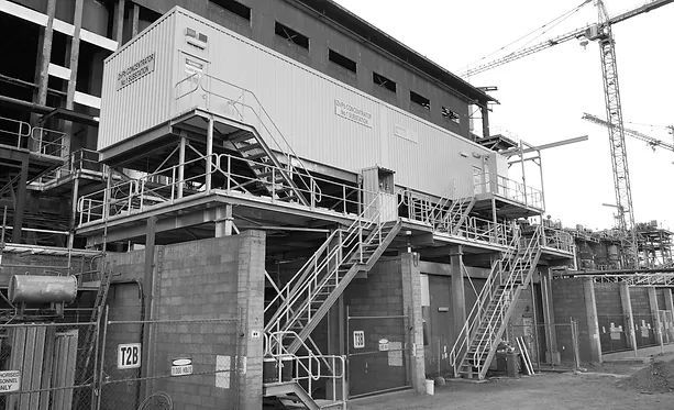 A Black and White Photo of A Building Under Construction with Stairs Leading up To It — Custom Steel Fab in Garbutt, QLD