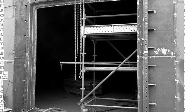 A Black and White Photo of A Building Under Construction with Scaffolding — Custom Steel Fab in Garbutt, QLD