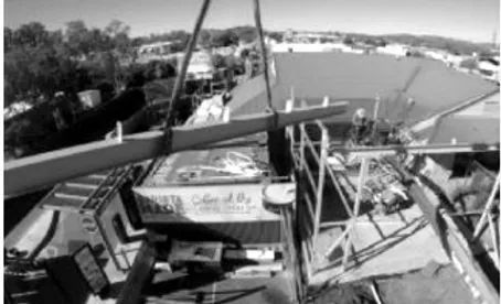 A Black and White Photo of A Crane Lifting a Building — Custom Steel Fab in Garbutt, QLD