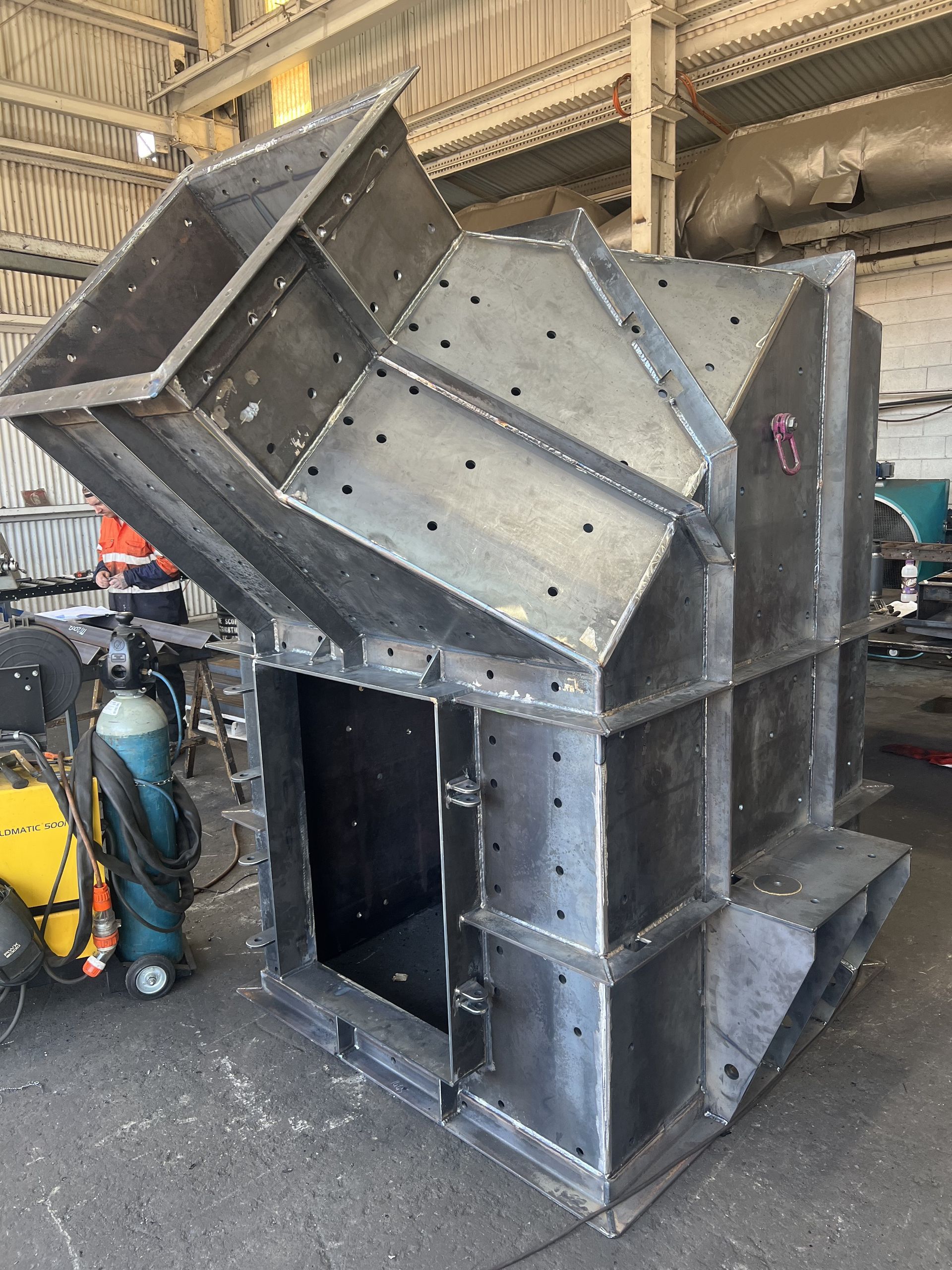 A Large Metal Structure Is Being Built In A Factory — Custom Steel Fab in Garbutt, QLD