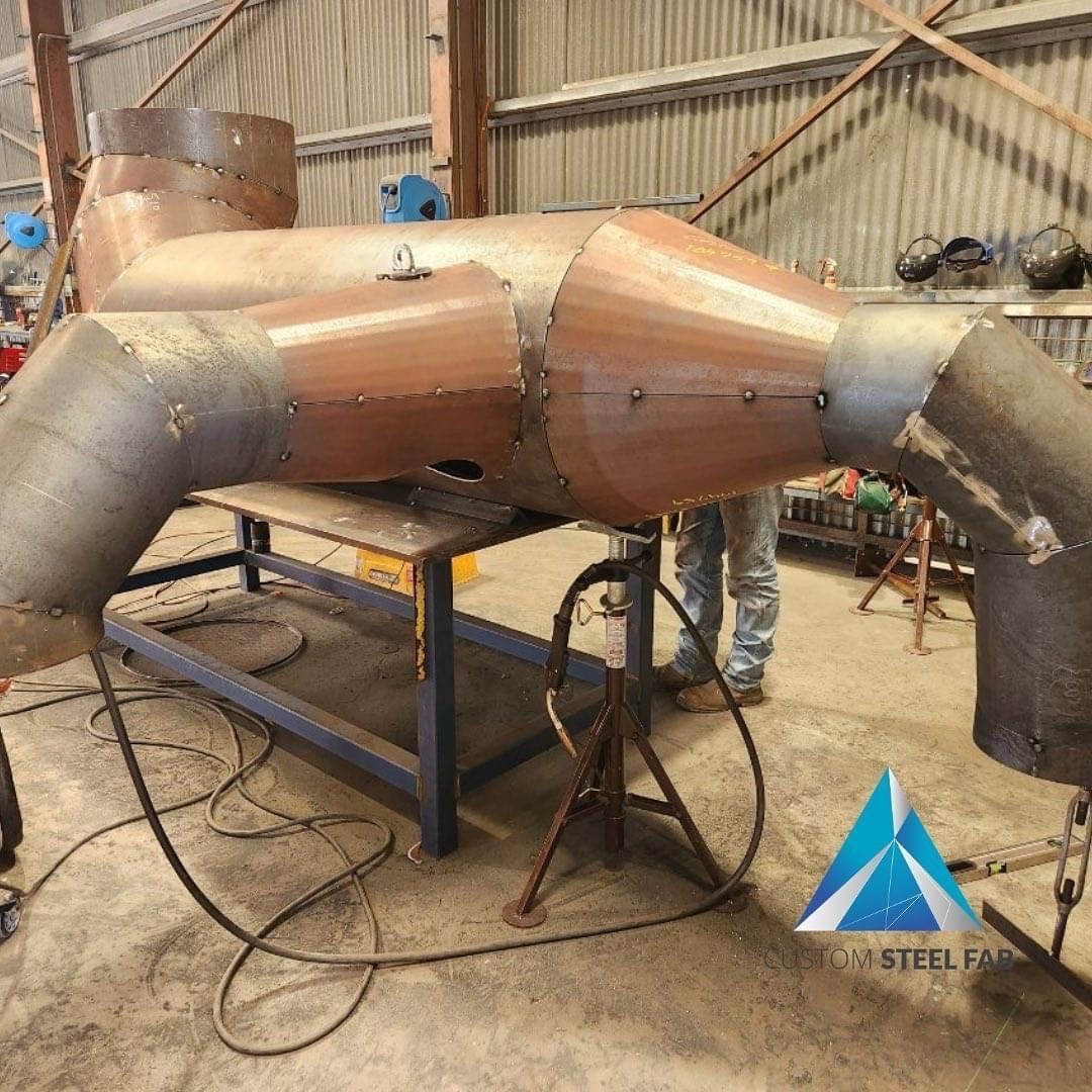 Large Copper-colored Metal Duct Assembly in a Workshop on a Table — Custom Steel Fab in Bohle, QLD