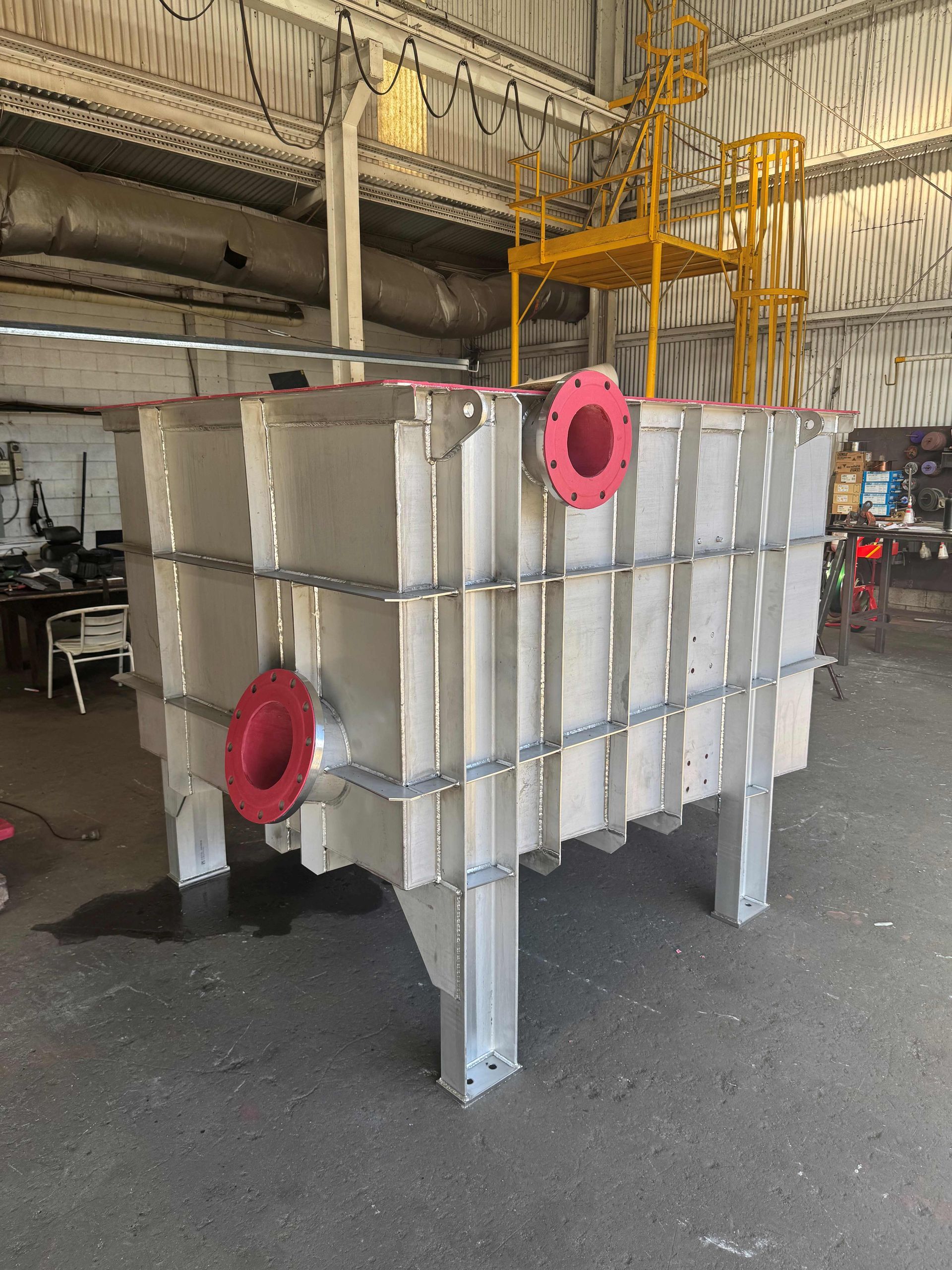 Large White Industrial Tank With Red Pipe Fittings in a Workshop — Custom Steel Fab in Bohle, QLD