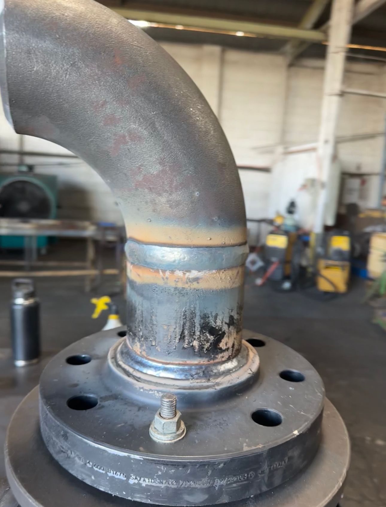 A Close Up Of A Metal Pipe Sitting On Top Of A Flange In A Factory — Custom Steel Fab in Garbutt, QLD