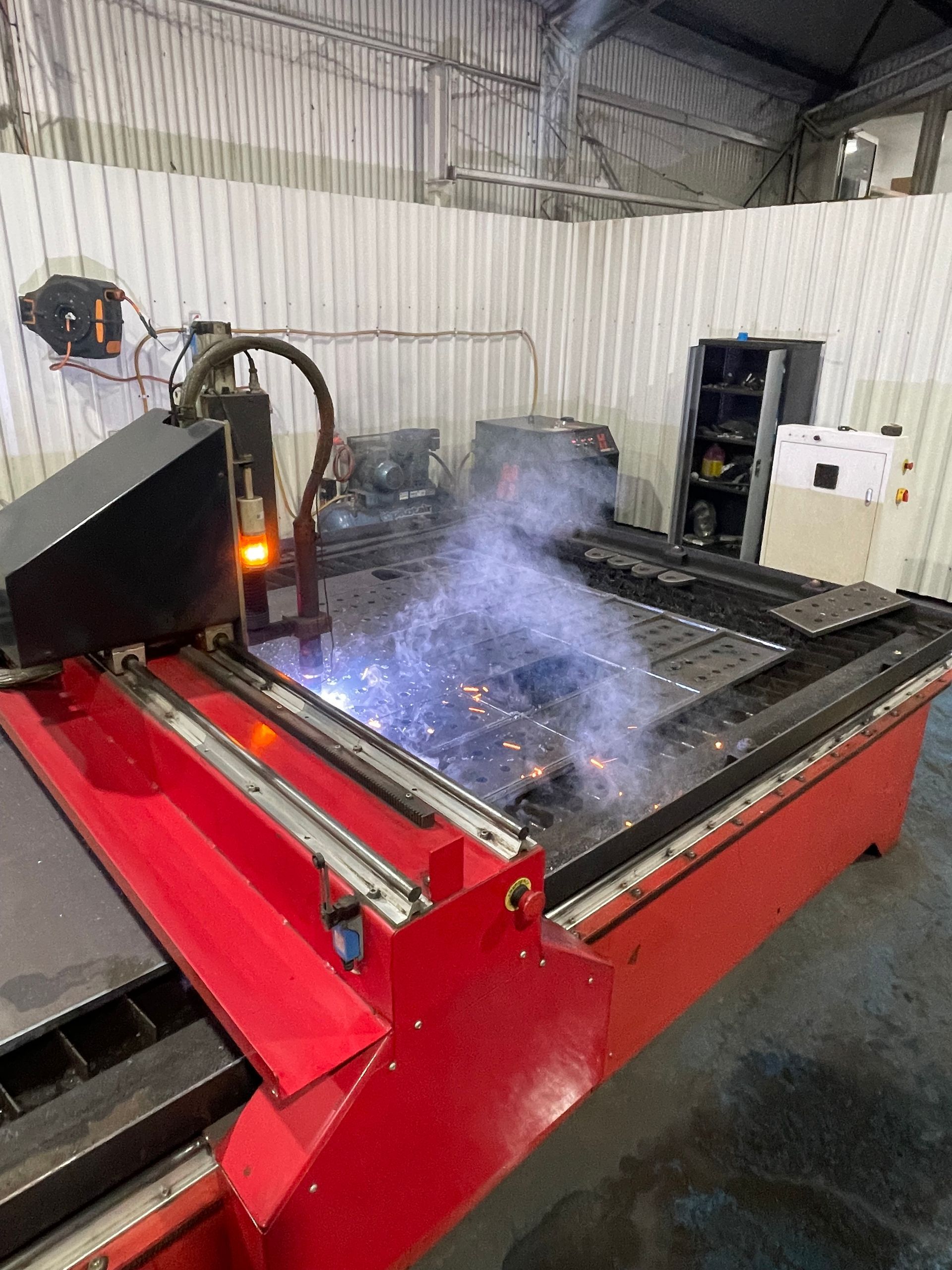 Industrial Cnc Cutting Machine Spraying Sparks and Smoke in a Workshop — Custom Steel Fab in Bohle, QLD