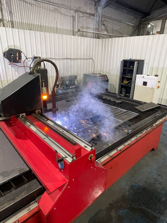 Industrial Cnc Cutting Machine Spraying Sparks and Smoke in a Workshop — Custom Steel Fab in Bohle, QLD