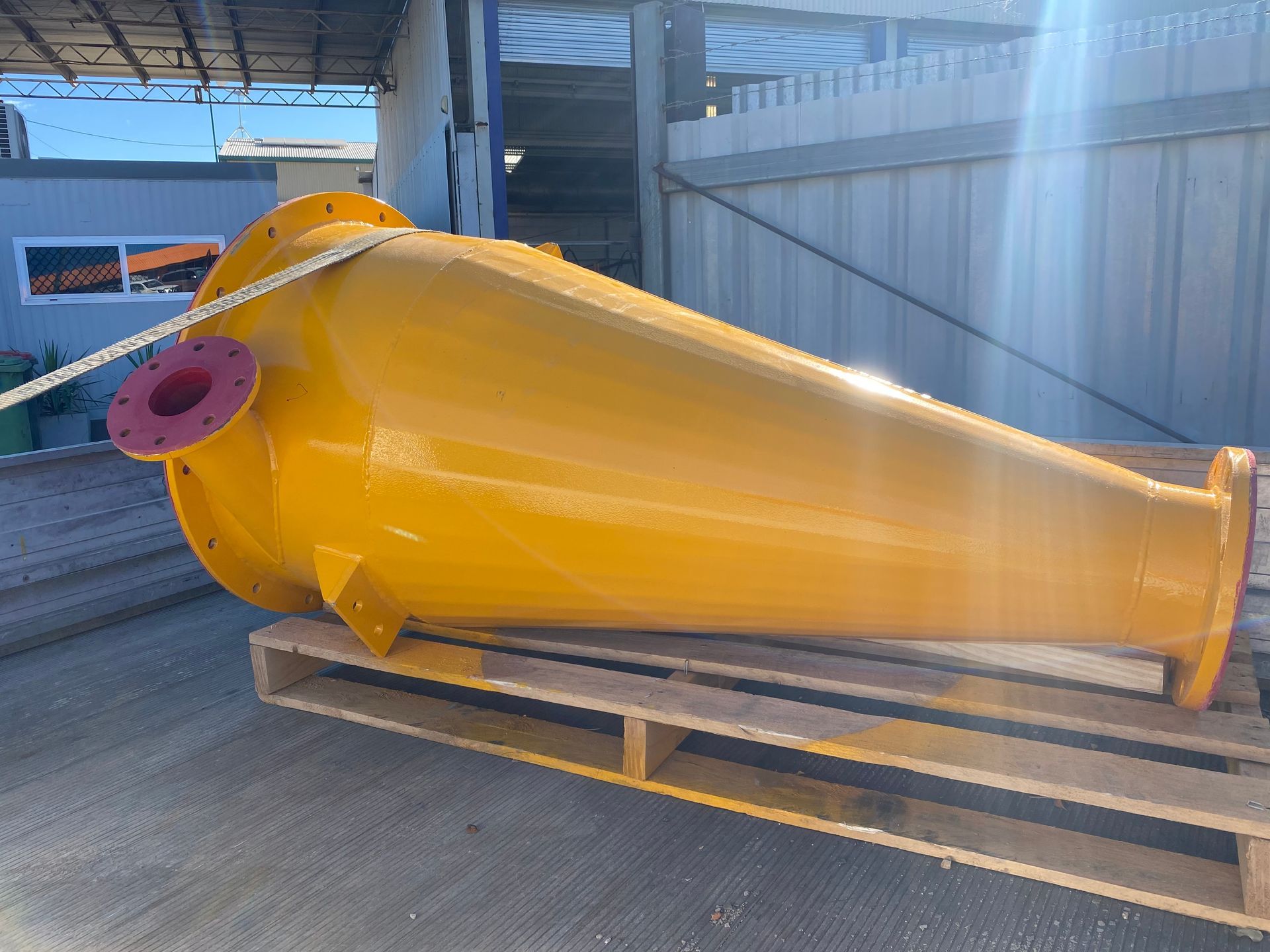 A Large Yellow Pipe Is Sitting On Top Of A Wooden Pallet — Custom Steel Fab in Garbutt, QLD