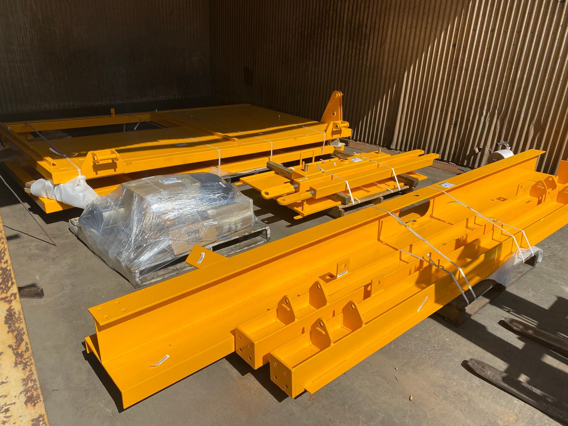 A Bunch Of Yellow Metal Pieces Are Wrapped In Plastic — Custom Steel Fab in Garbutt, QLD