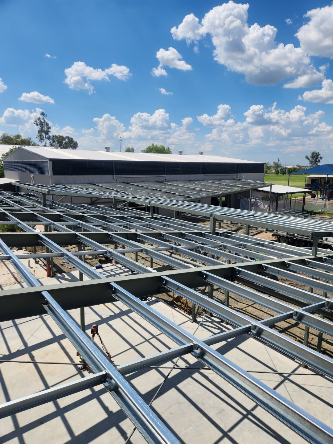 A Large Metal Structure Is Being Built On Top Of A Building — Custom Steel Fab in Garbutt, QLD