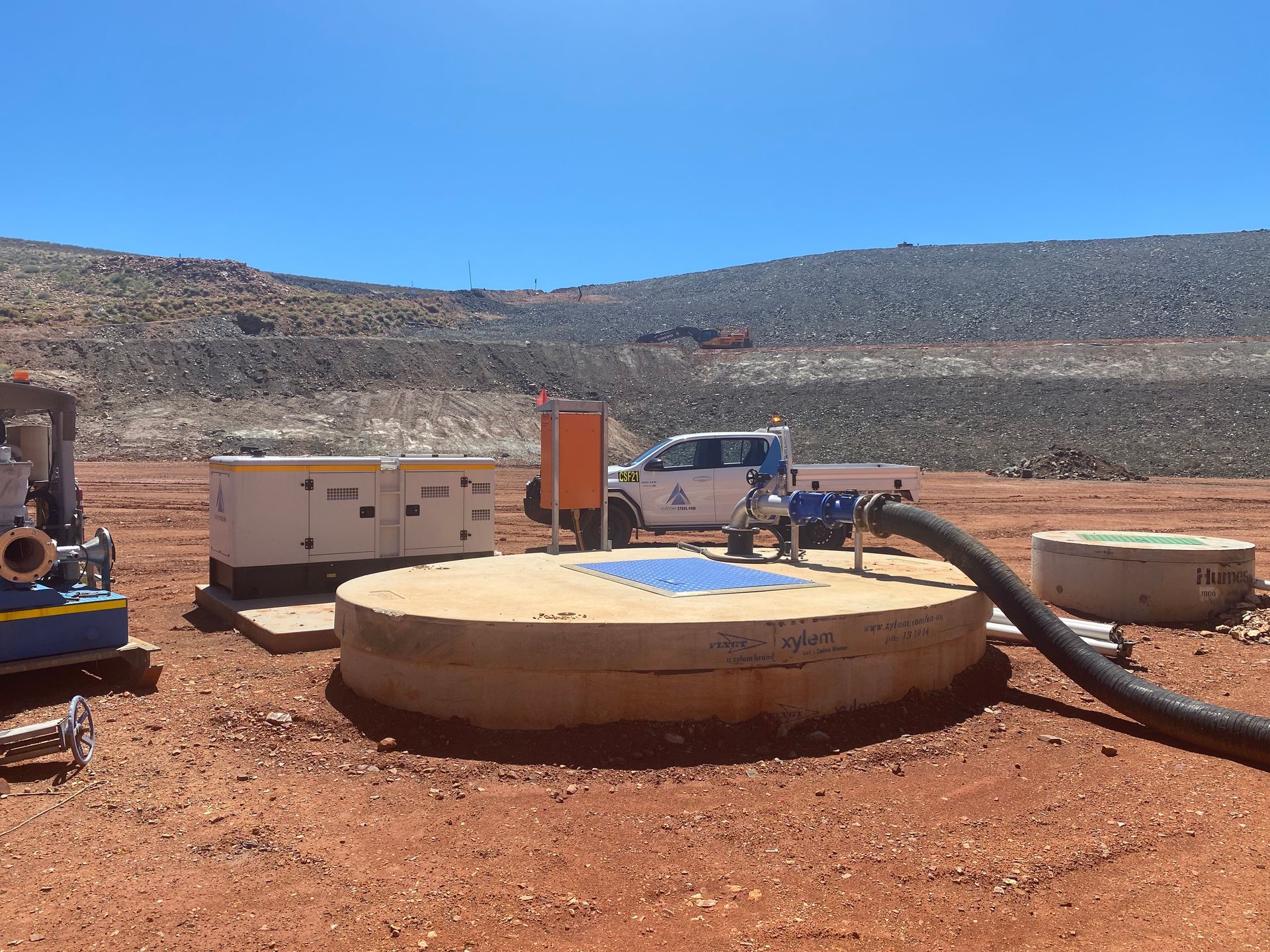 Desert Industrial Site With Large Circular Tank, Trucks, and Equipment — Custom Steel Fab in Bohle, QLD