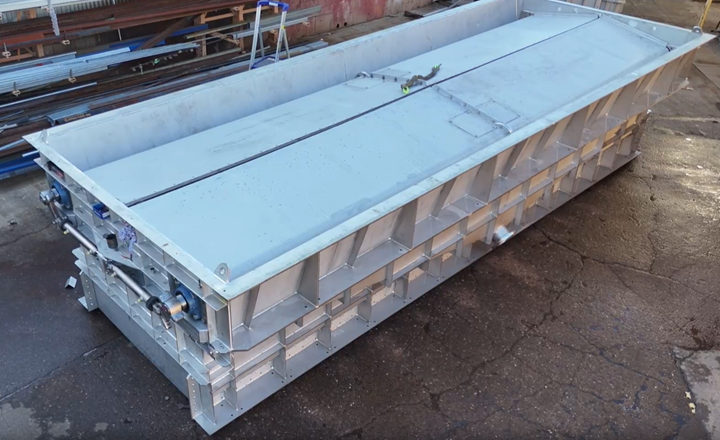 Stacked metal containers with blue lids on a rooftop or industrial surface