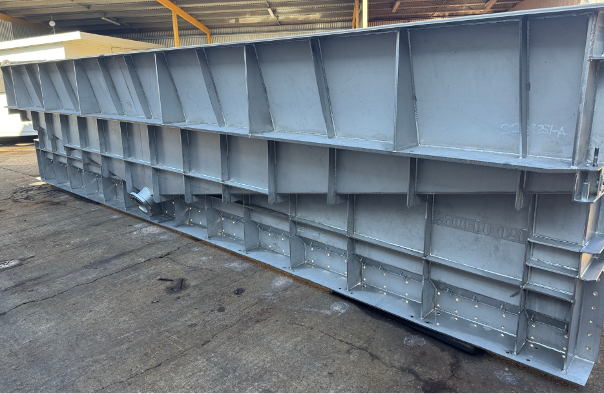 Large gray steel beam structure inside an industrial warehouse