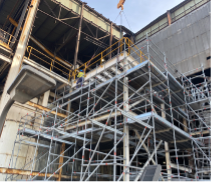 A Black and White Photo of A Crane Lifting a Building — Custom Steel Fab in Garbutt, QLD