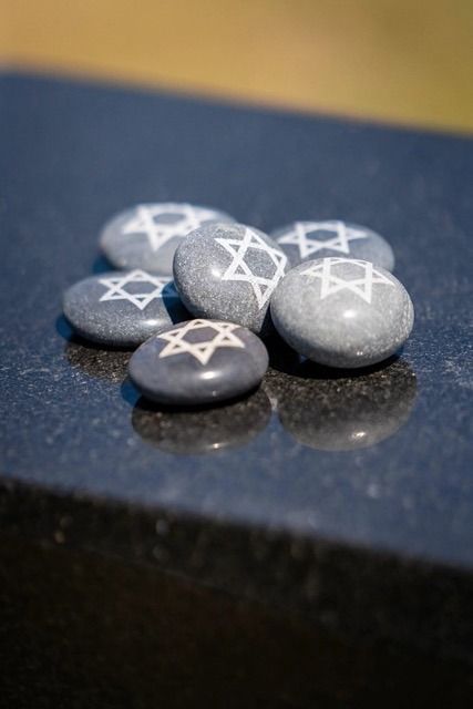 Small gray stones with white star symbols on a dark reflective surface