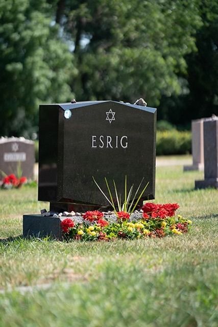 Black ESRIG gravestone with flowers in a cemetery