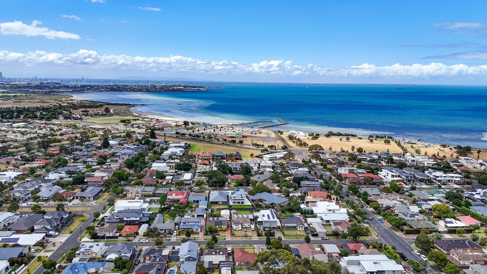 Aerial view featuring a beach, suburban neighbourhood, and a beautiful coastline.