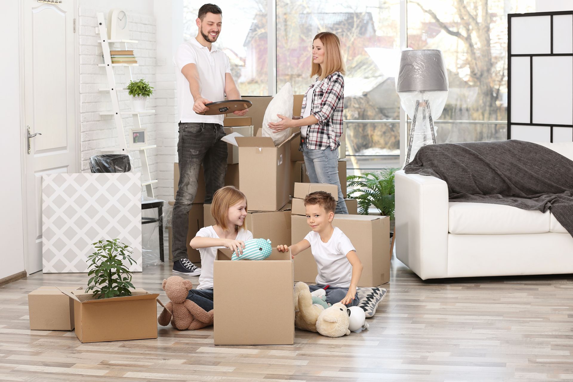 A family unpacking cardboard boxes in a new home. A family unpacking cardboard boxes in a new home.