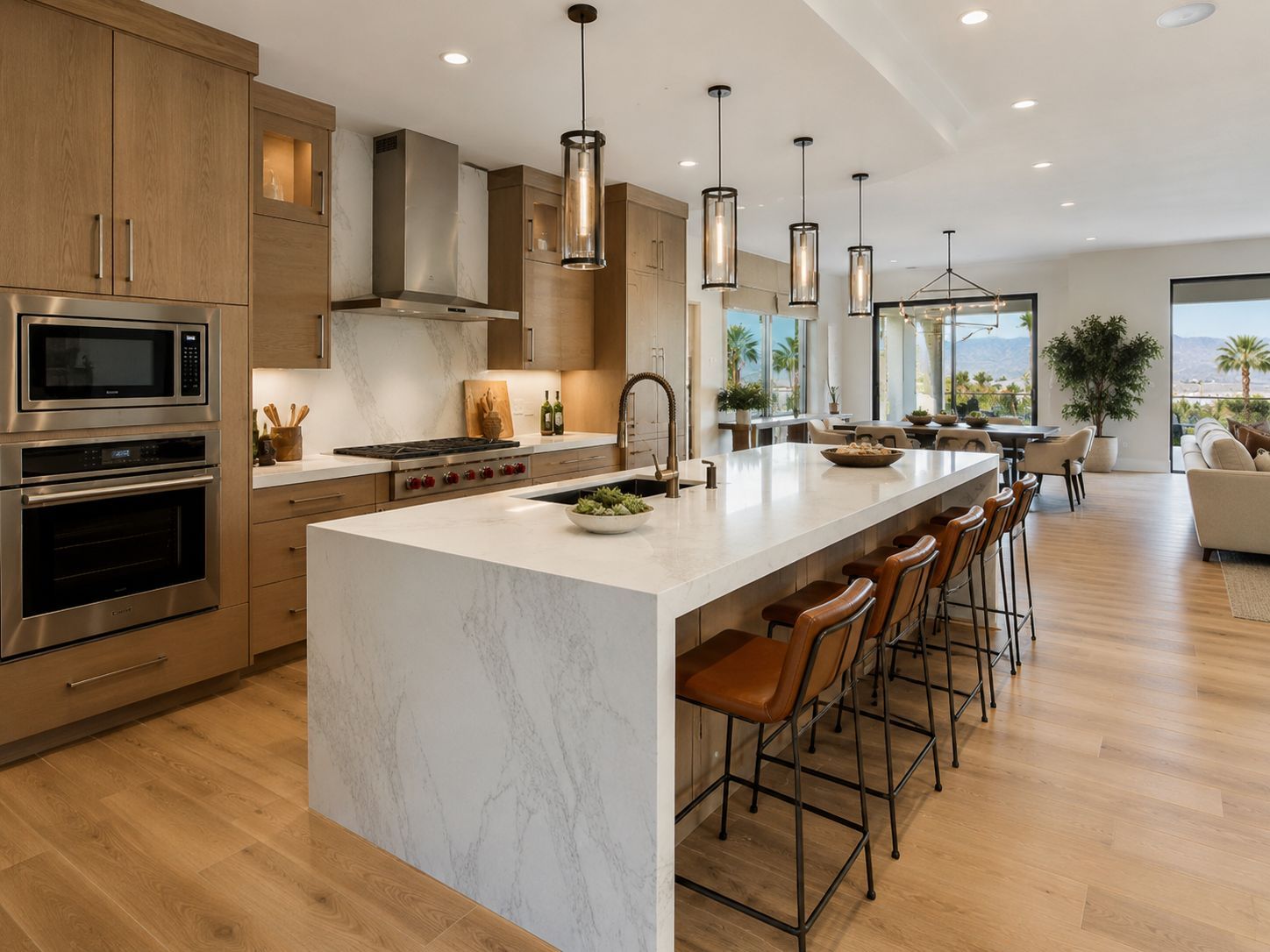Bright white modern kitchen with island, stainless steel appliances, and wood floors