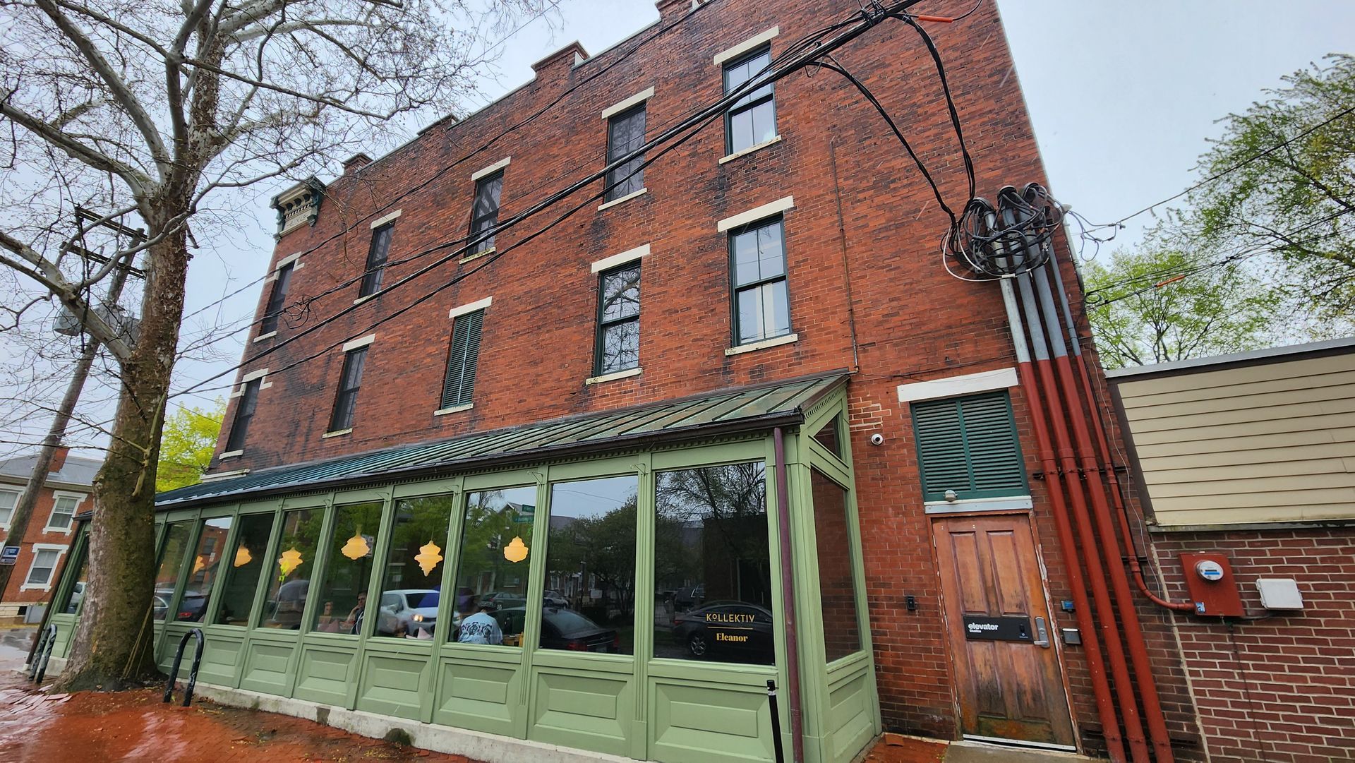 A large brick building with a green awning on the side of it.