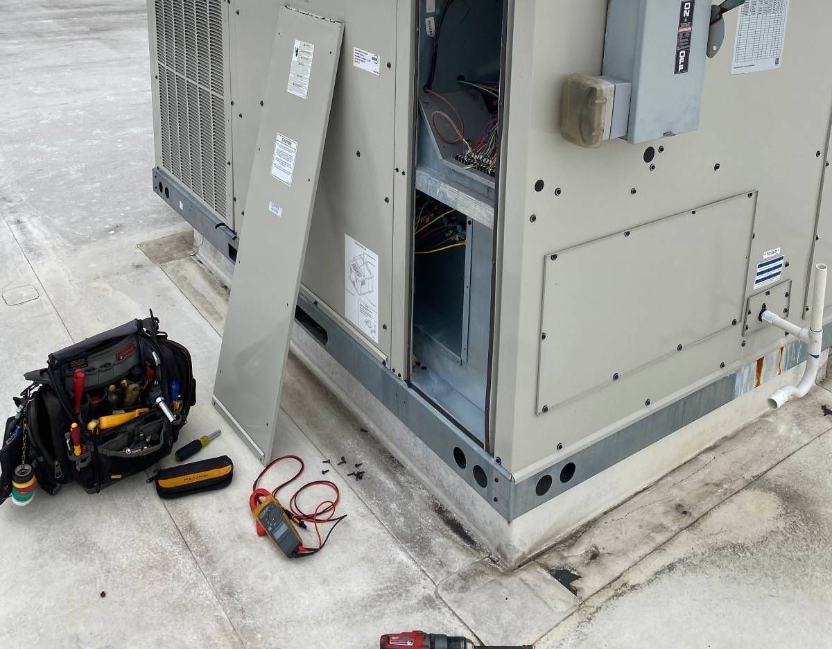 Open electrical equipment outdoors with tools and cables on the ground