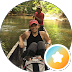 Three people posing on an ATV outdoors in a forest, with a star badge overlay in the corner