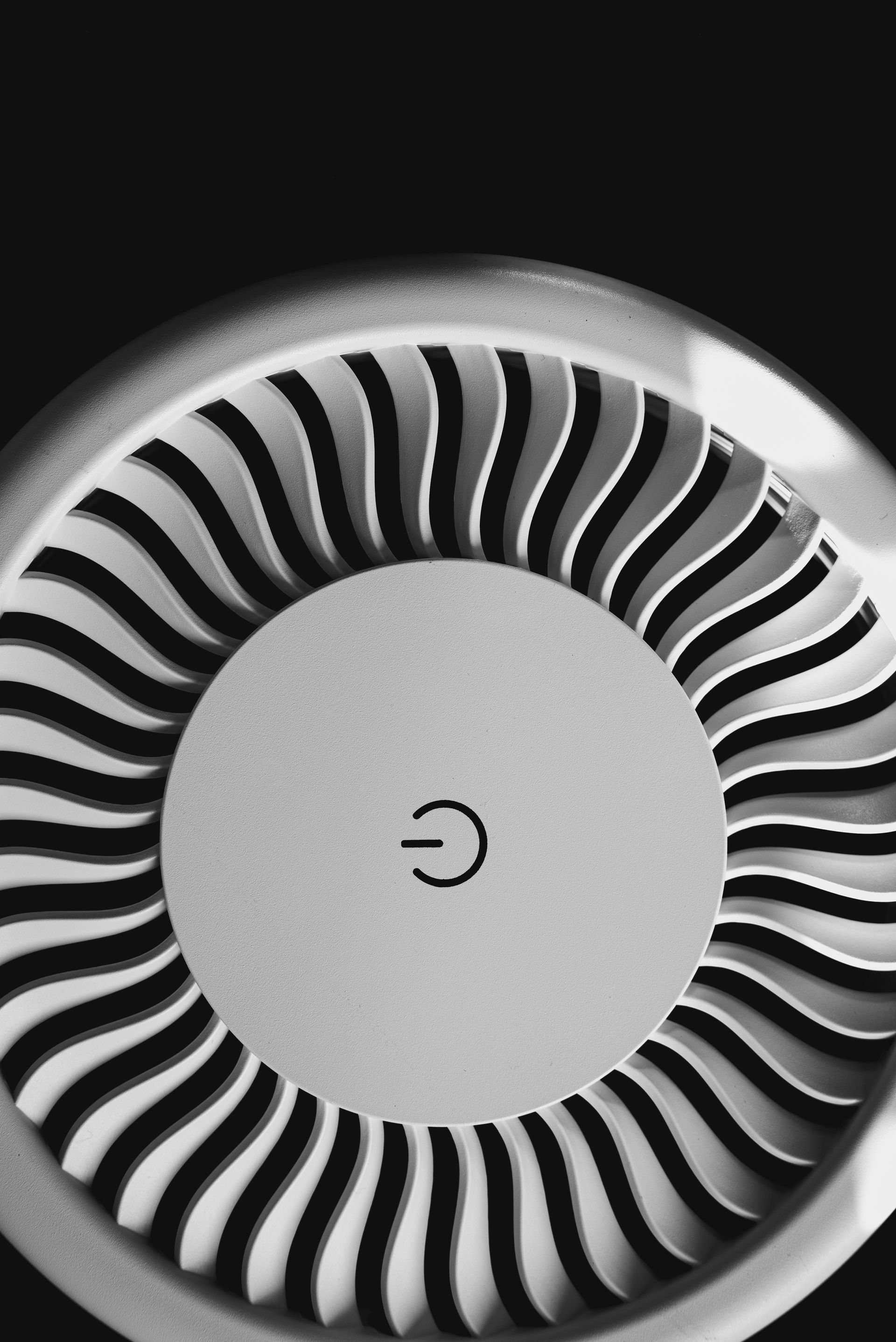 Black-and-white vent with a circular swirl pattern around a gray center.