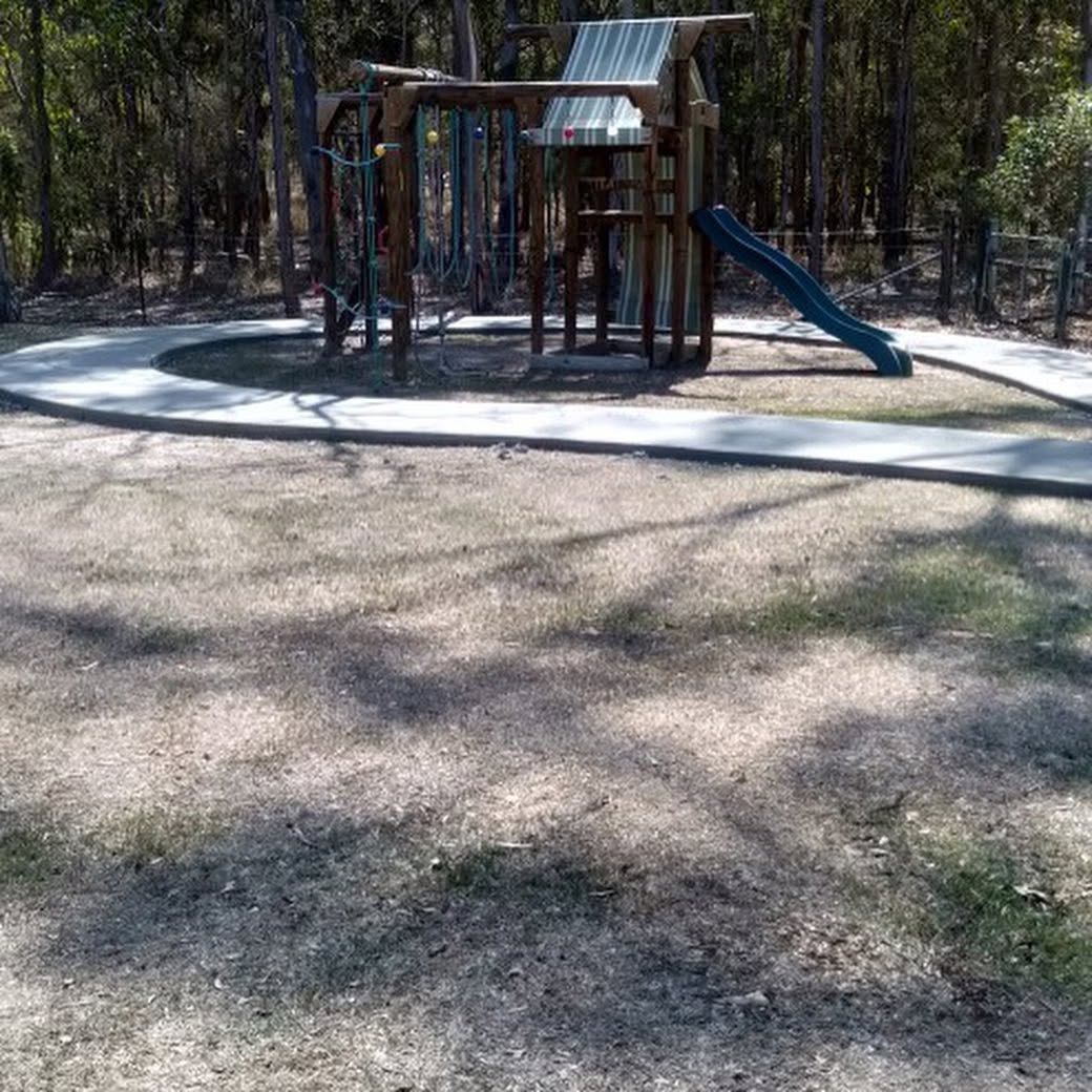 Children’s playground with a slide and climbing frame in a wooded park area