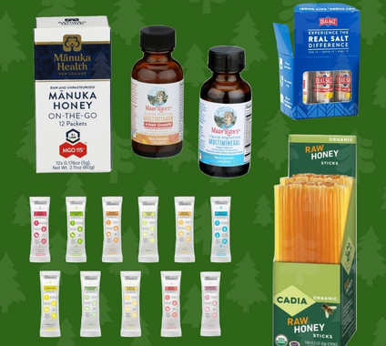 Assorted honey products and packets arranged on a green background, including jars, boxes, and stick packs