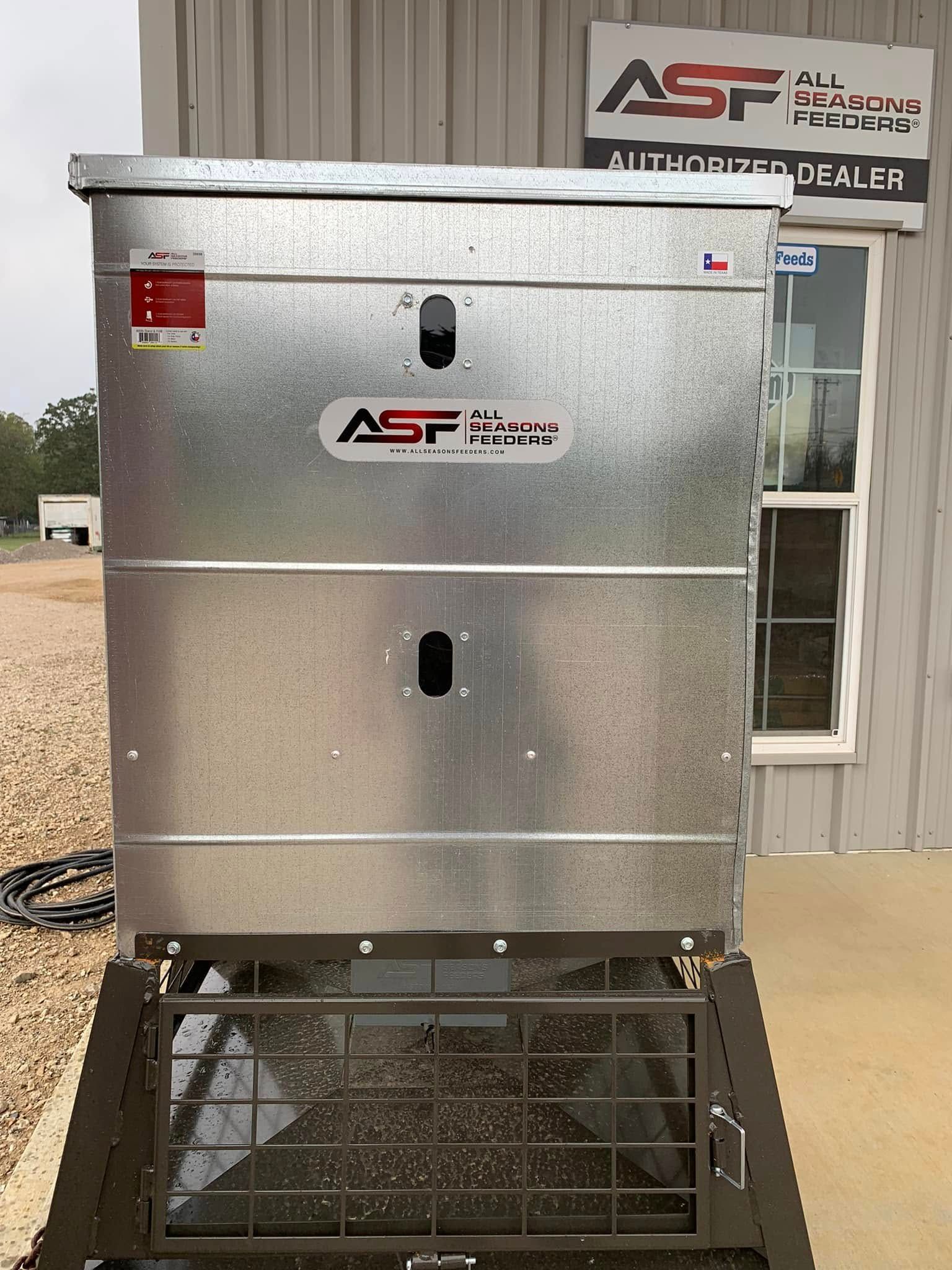 Silver industrial machine on a metal stand outside a building with an ASF sign.