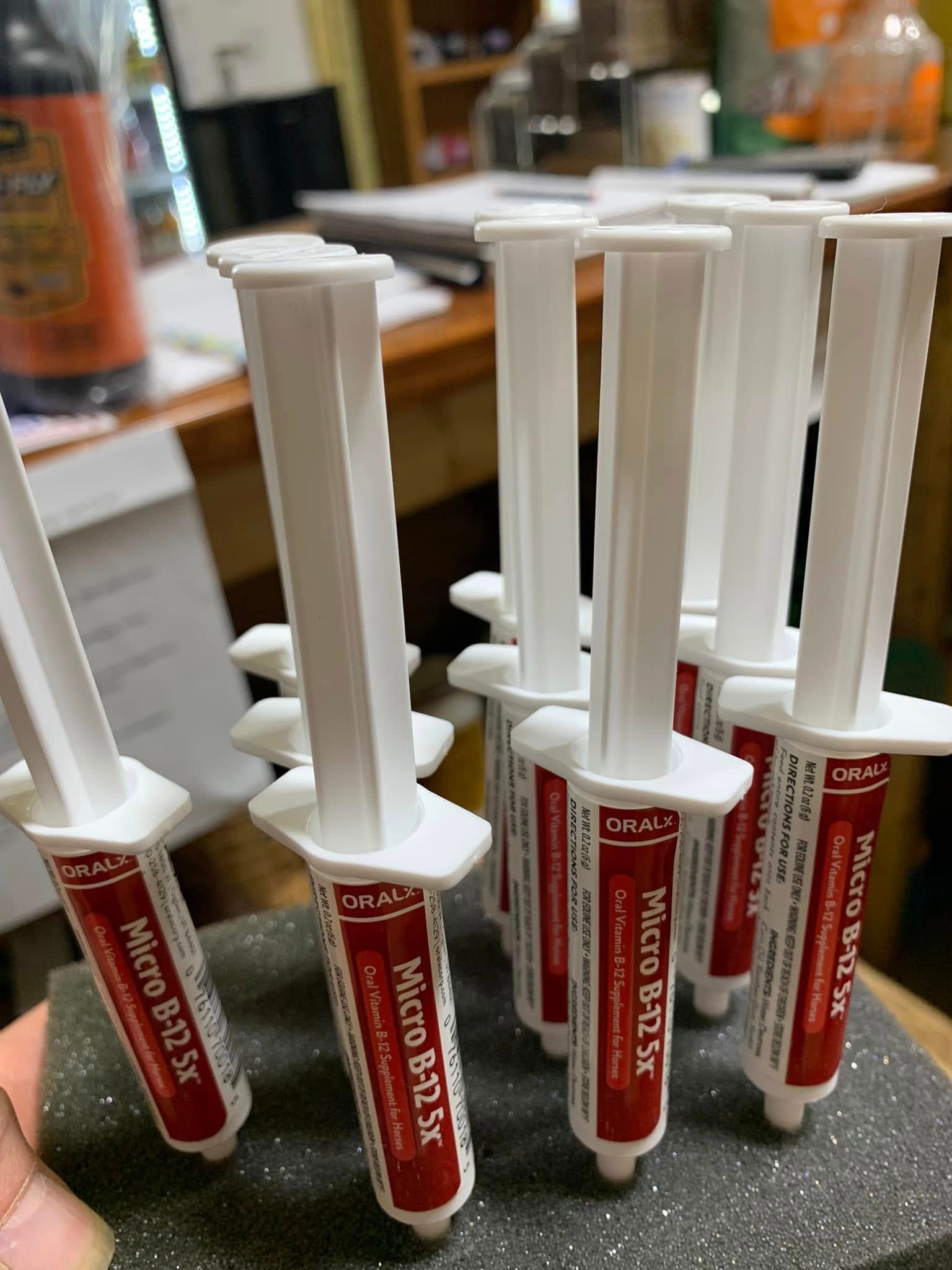 Several red-and-white medicine syringes standing upright on a table