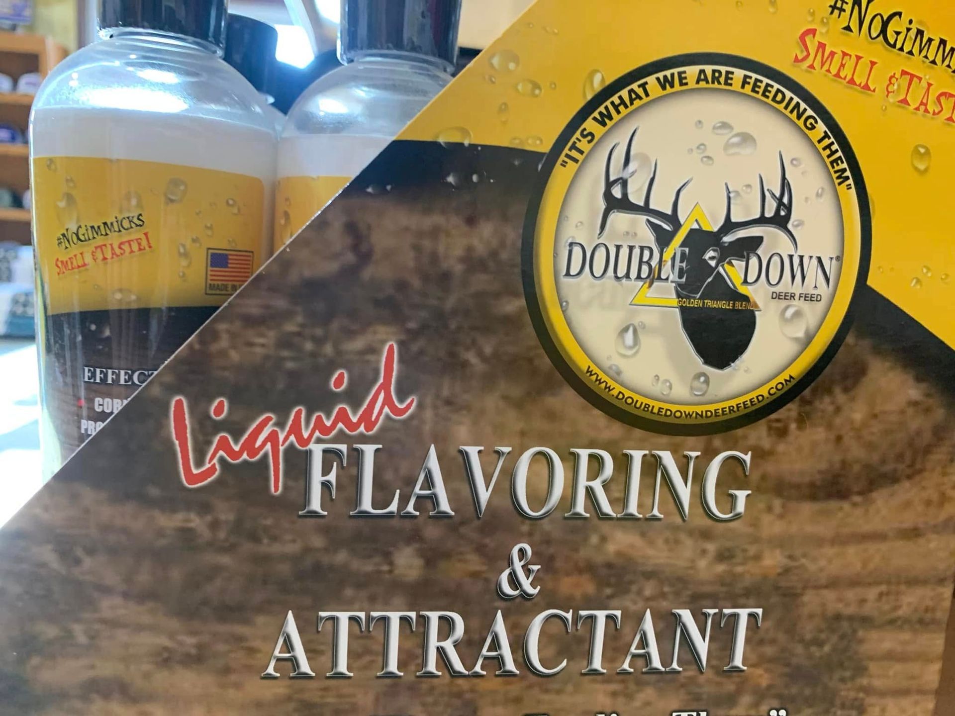 Bottles of liquid flavoring and attractant with a yellow-and-black label on a shelf.